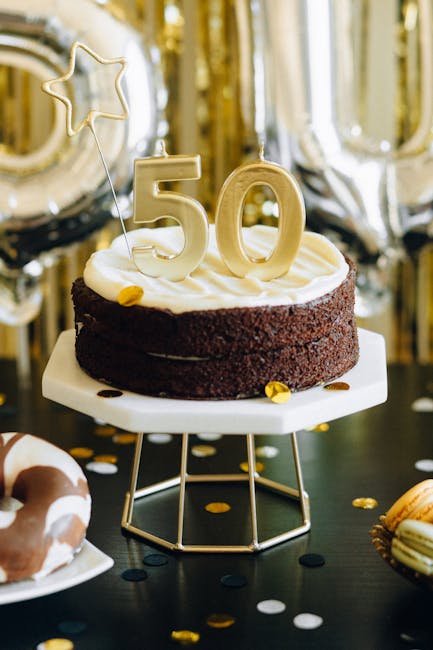 Celebrate a golden 50th birthday with a chocolate cake adorned with candles and star decorations.
