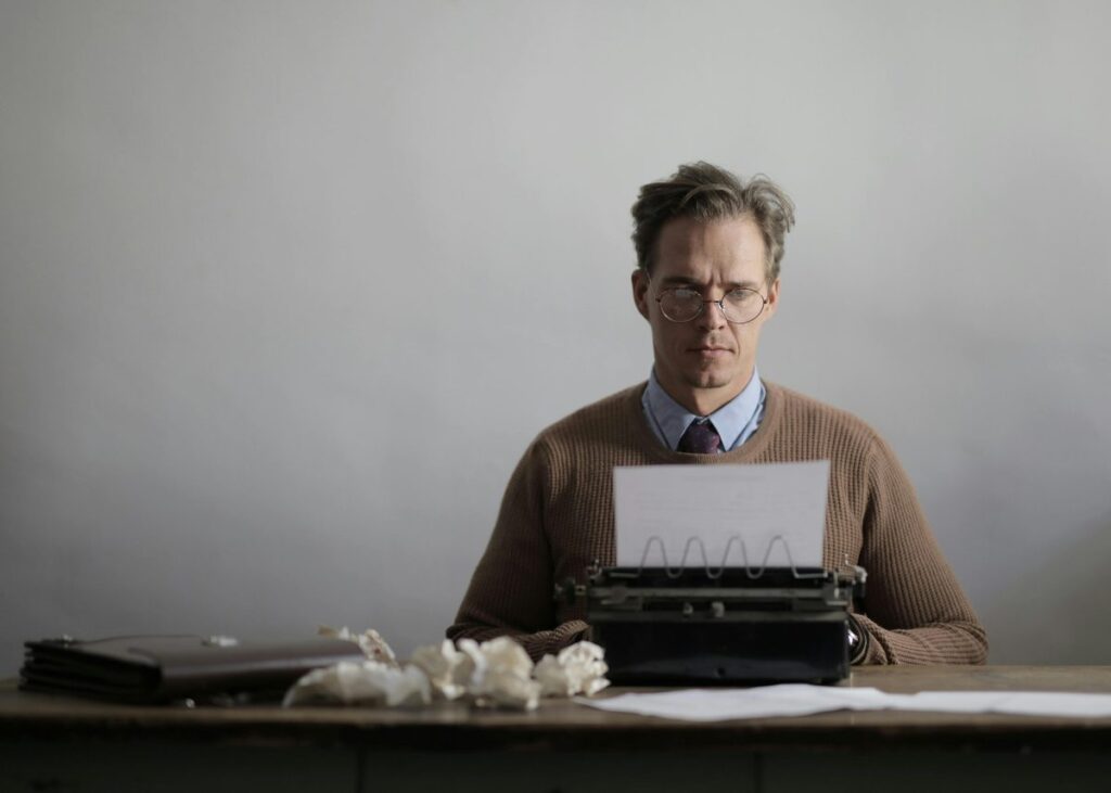man typing on typewriter