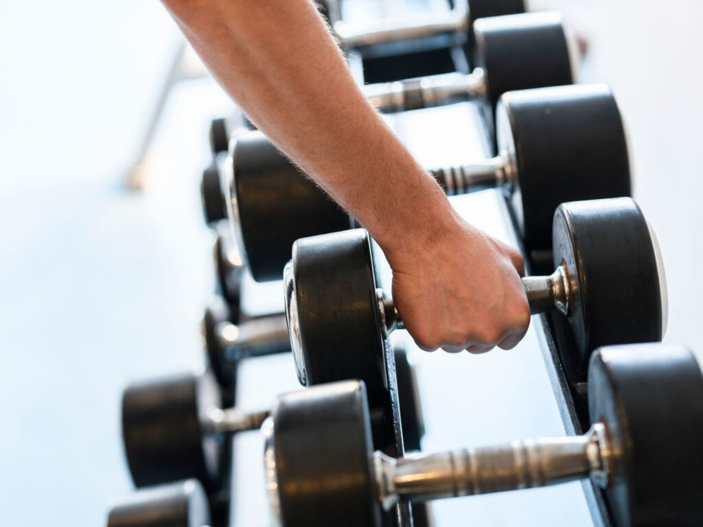 a hand grabbing a dumbell weight