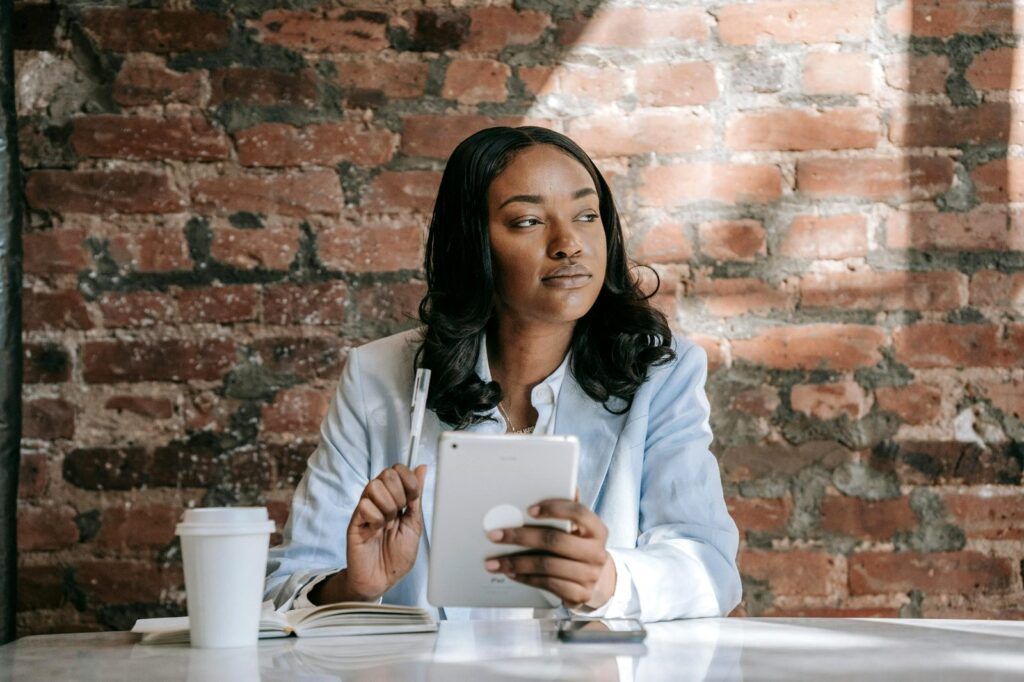 woman thinking with a notebook and pen in hand