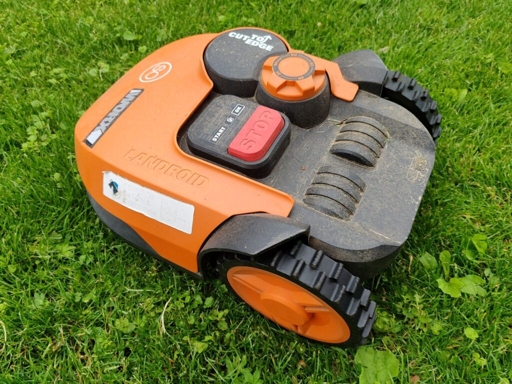 orange robot mower on grass