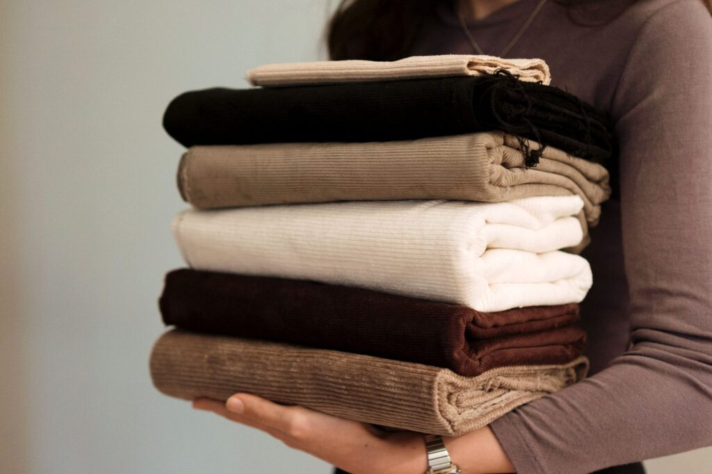 woman carrying folded towels